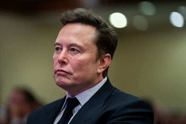 Elon Musk listens as US President-elect Donald Trump speaks during a House Republicans Conference meeting at the Hyatt Regency on Capitol Hill on November 13, 2024 in Washington, DC. 